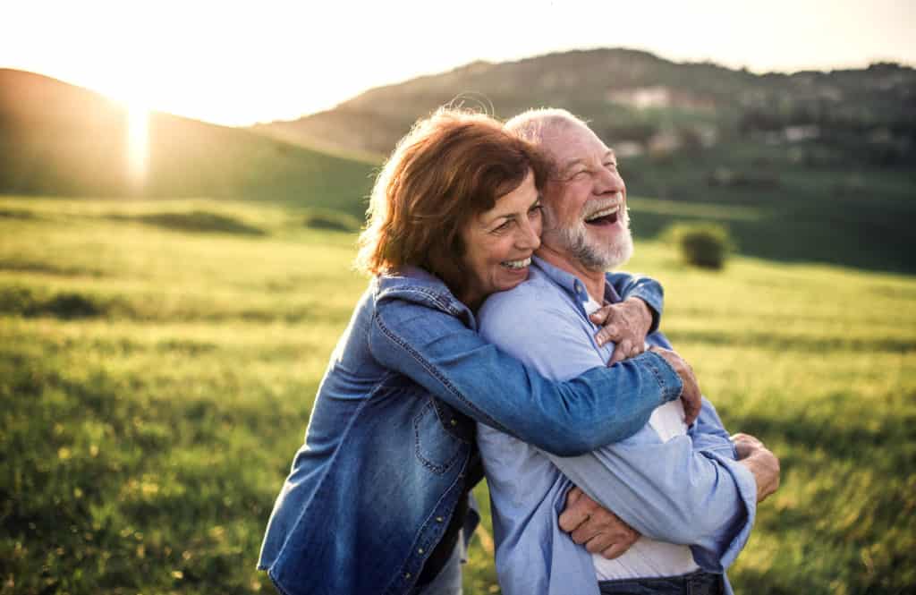 Side-view-of-senior-couple-hugging-outside-in-spring-nature-at-sunset.-1027141710_5568x3616-1024x665-1