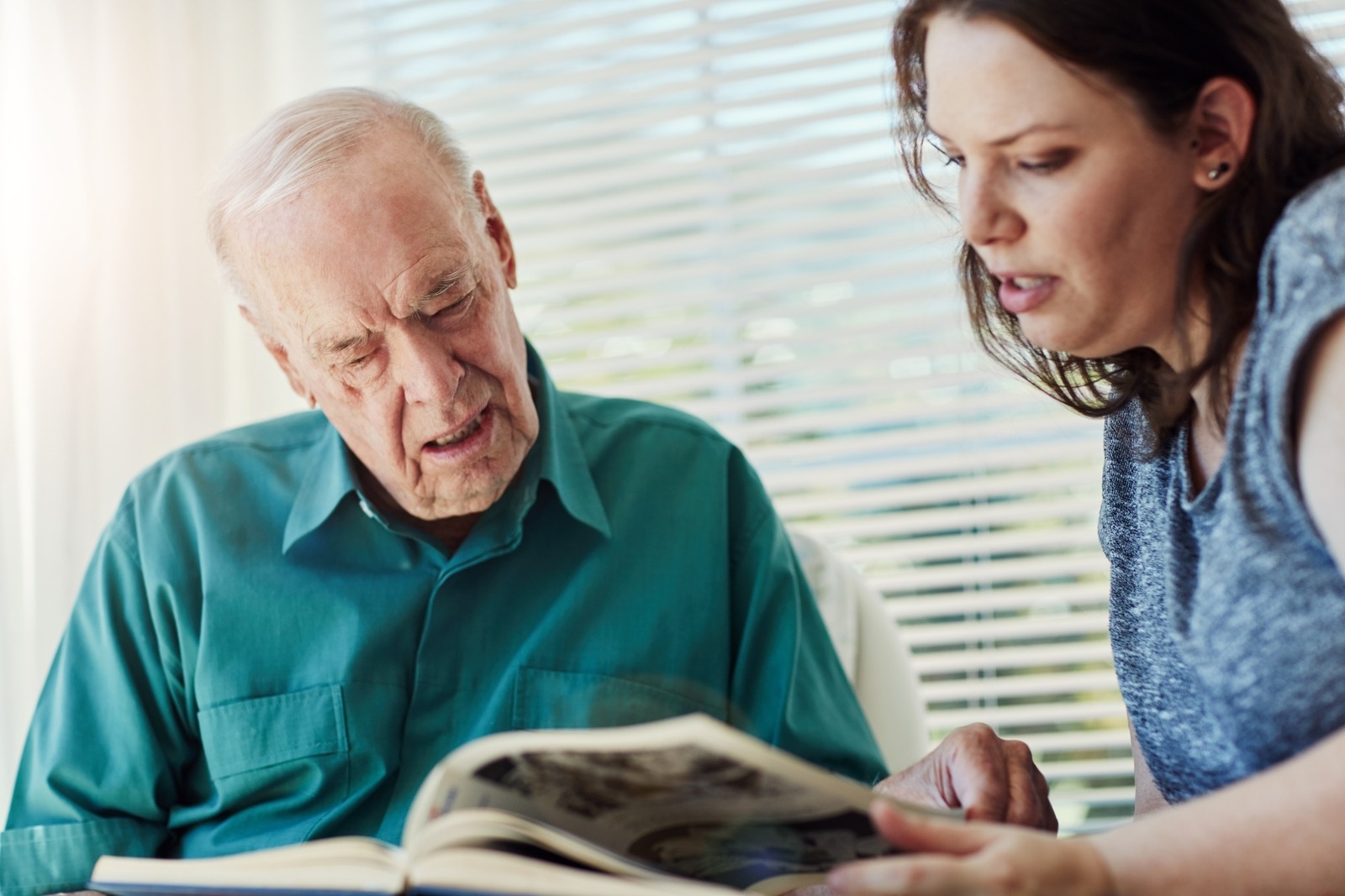 Senior dad, woman and picture book for reminder, dementia and reflection for past life